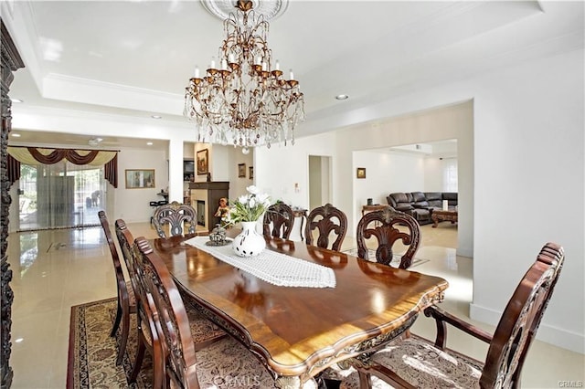 tiled dining area featuring a raised ceiling and a chandelier