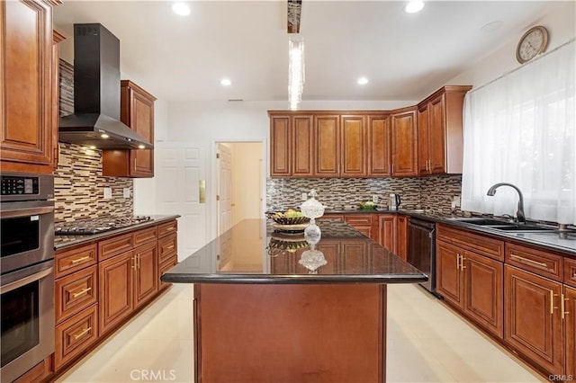 kitchen with appliances with stainless steel finishes, sink, dark stone countertops, a center island, and wall chimney exhaust hood