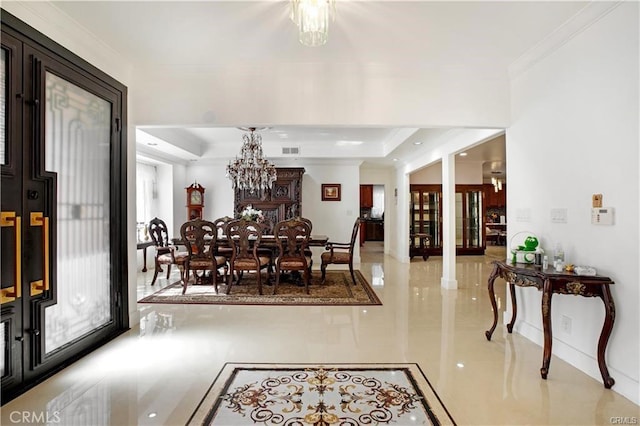 dining area with an inviting chandelier, crown molding, and a raised ceiling