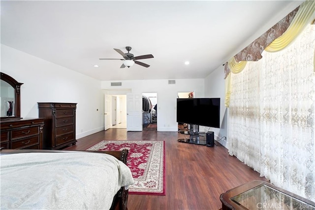 bedroom featuring a closet, a walk in closet, dark hardwood / wood-style floors, and ceiling fan