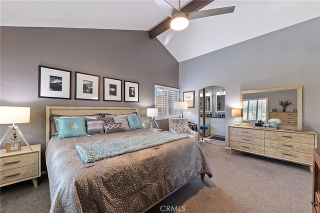 bedroom with ceiling fan, high vaulted ceiling, ensuite bathroom, carpet floors, and beamed ceiling