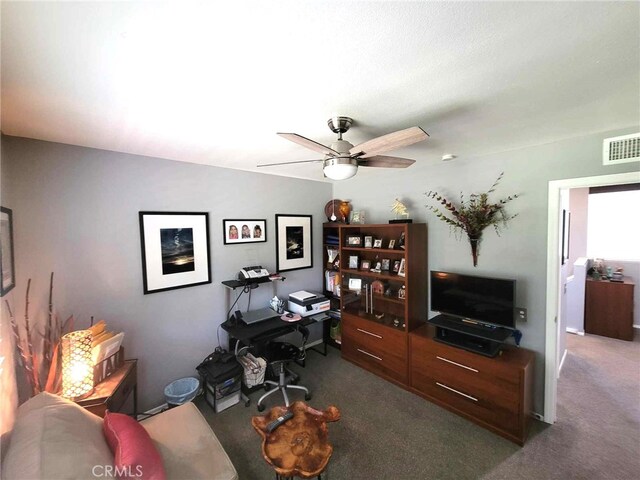 carpeted office space featuring ceiling fan