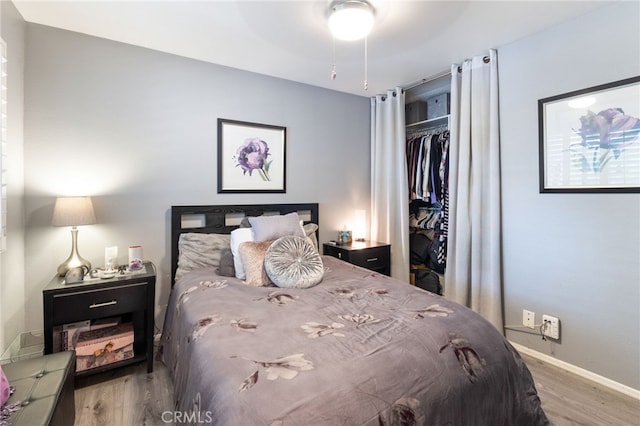 bedroom with hardwood / wood-style floors, ceiling fan, and a closet