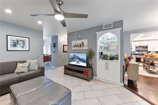 living room featuring ceiling fan and light tile patterned floors