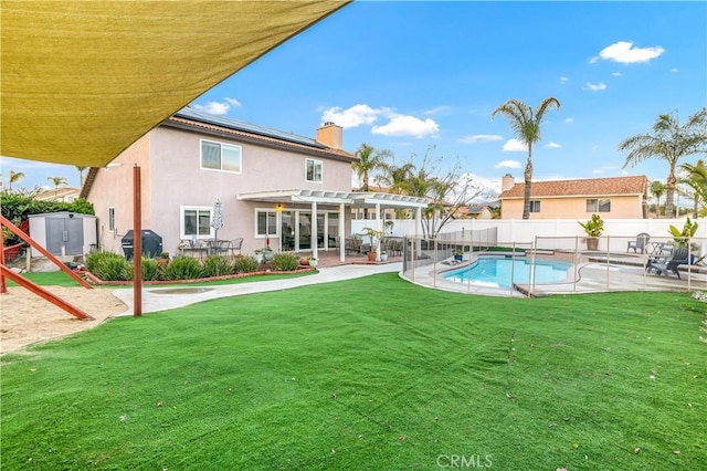 back of property featuring a fenced in pool, a storage shed, a pergola, and a patio