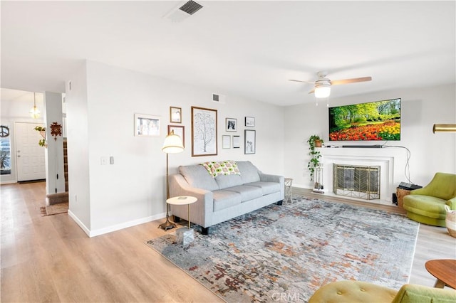 living room with ceiling fan and light hardwood / wood-style floors