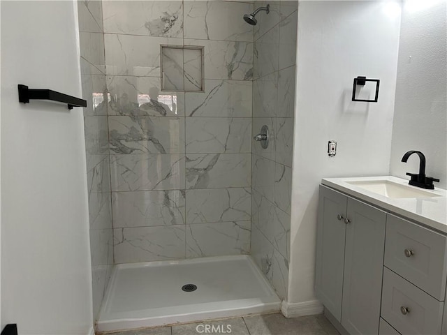 bathroom featuring tiled shower and vanity