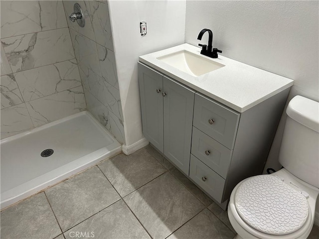 bathroom with vanity, tiled shower, and toilet