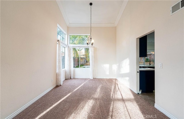 unfurnished dining area with ornamental molding, carpet floors, and a chandelier