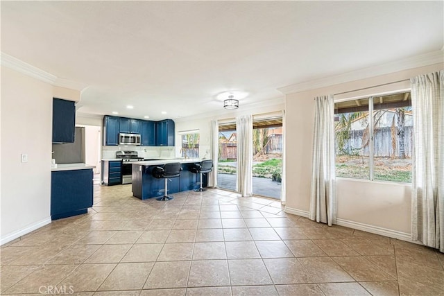 kitchen featuring appliances with stainless steel finishes, a kitchen bar, crown molding, plenty of natural light, and blue cabinetry