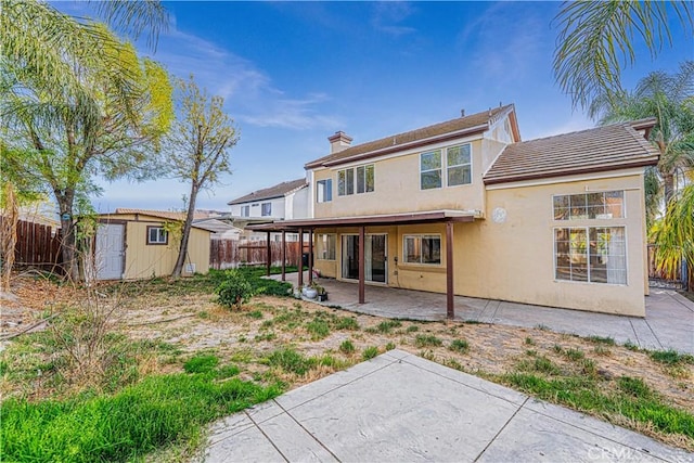 rear view of house featuring a storage shed and a patio area