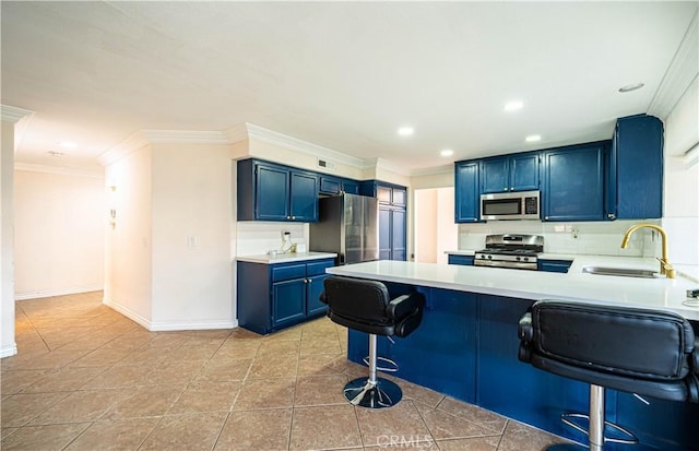 kitchen featuring sink, blue cabinetry, a breakfast bar, stainless steel appliances, and kitchen peninsula