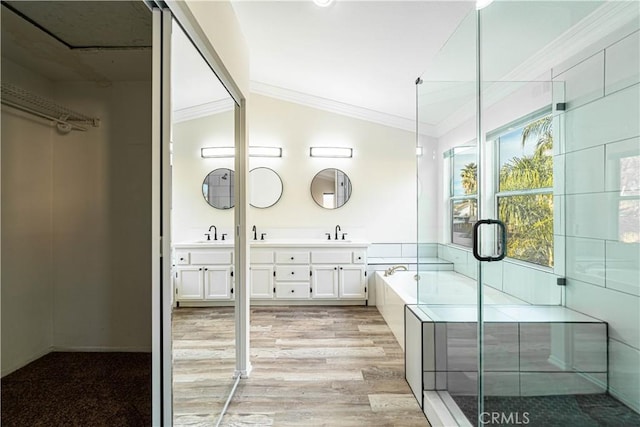 bathroom featuring wood-type flooring, lofted ceiling, shower with separate bathtub, and vanity