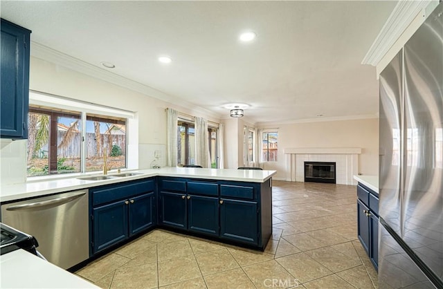 kitchen featuring blue cabinetry, light tile patterned floors, ornamental molding, kitchen peninsula, and stainless steel appliances