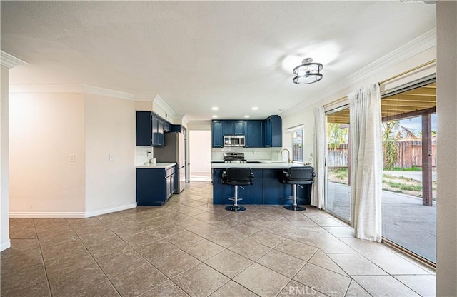 kitchen featuring blue cabinetry, a breakfast bar, ornamental molding, kitchen peninsula, and stainless steel appliances