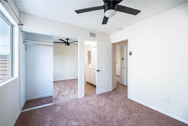 unfurnished bedroom featuring ceiling fan, ensuite bathroom, carpet floors, and a closet