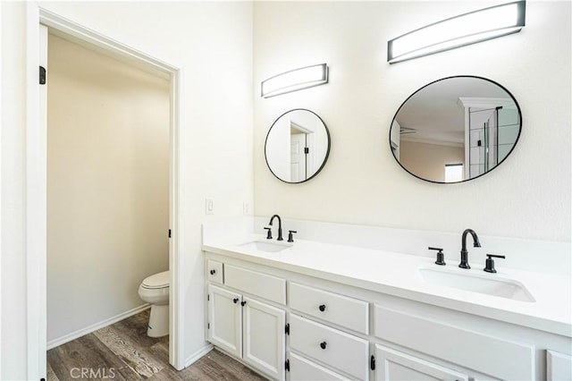 bathroom with wood-type flooring, vanity, and toilet