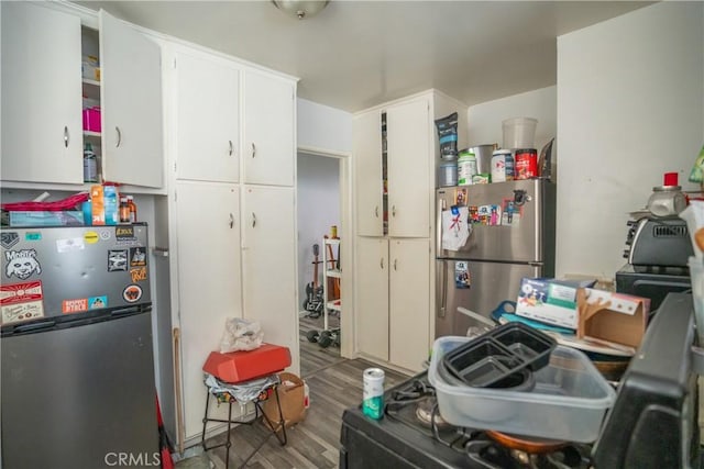 kitchen featuring stainless steel refrigerator, white cabinetry, and hardwood / wood-style flooring