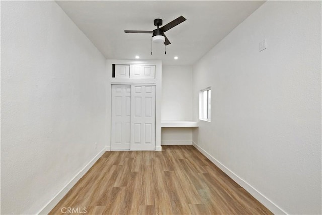 unfurnished bedroom featuring light hardwood / wood-style floors, ceiling fan, and a closet