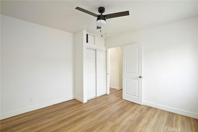 unfurnished bedroom featuring light hardwood / wood-style flooring, a closet, and ceiling fan