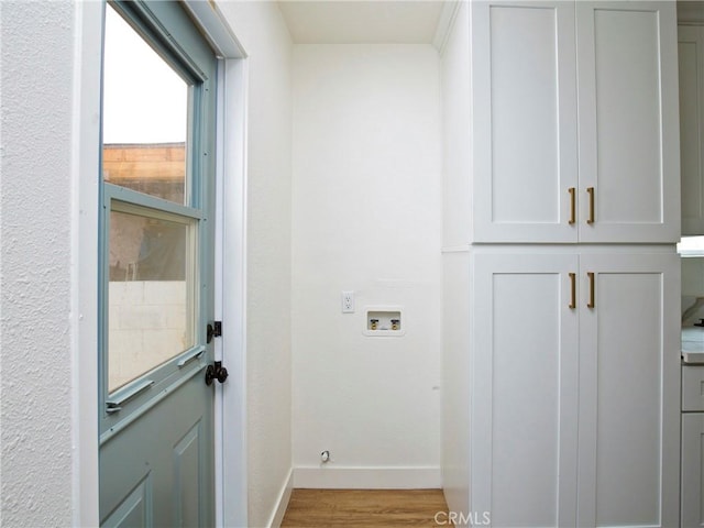 laundry room featuring hookup for a washing machine, light hardwood / wood-style flooring, and cabinets