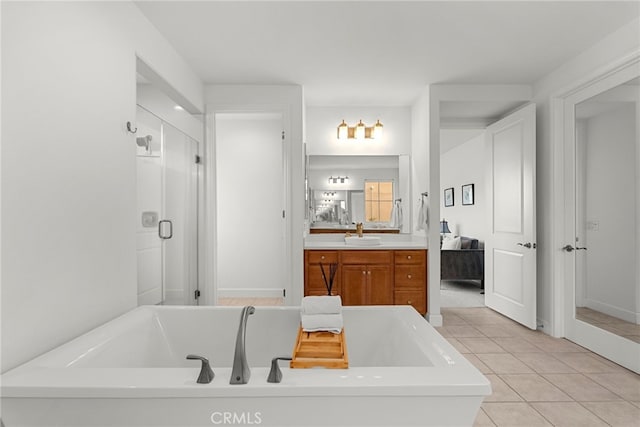 bathroom with a bathing tub, ensuite bathroom, vanity, a shower stall, and tile patterned flooring