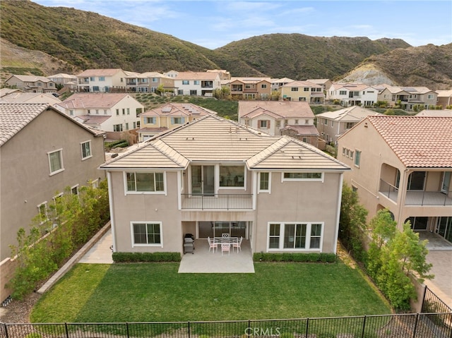 rear view of property with a yard, a patio, a residential view, and a mountain view