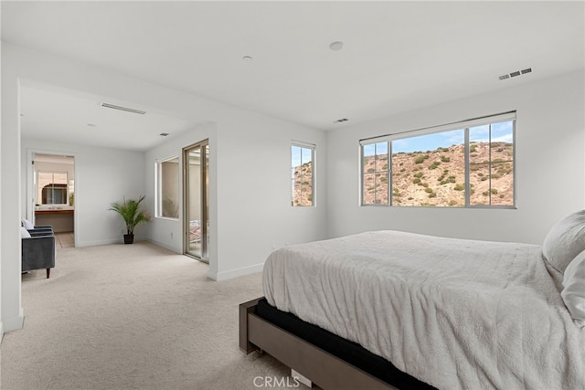 bedroom with light carpet, baseboards, multiple windows, and visible vents