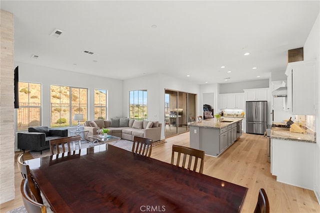 dining space with light wood finished floors, visible vents, and recessed lighting