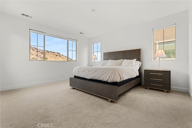 bedroom featuring light carpet, visible vents, and baseboards