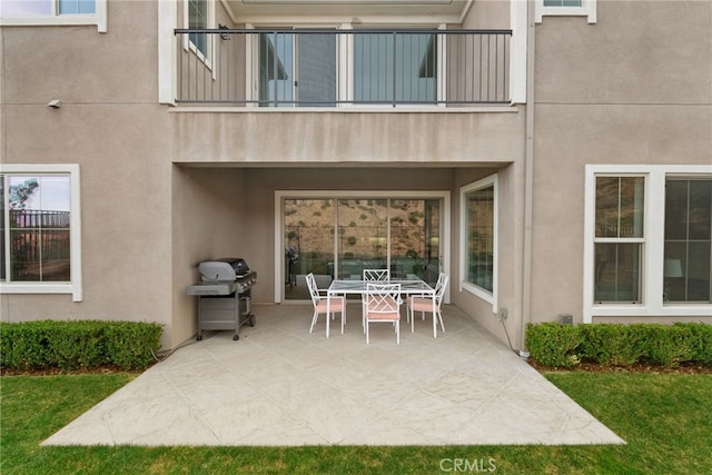 view of patio with a balcony, area for grilling, and outdoor dining space