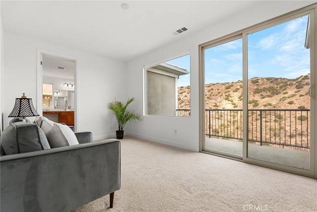 living area featuring a mountain view, carpet floors, visible vents, and baseboards