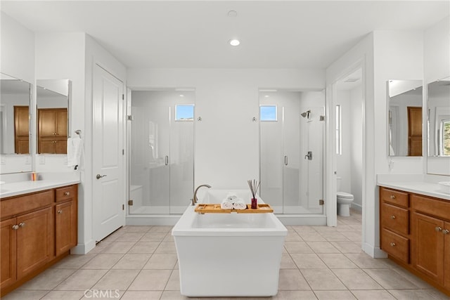 bathroom with a freestanding tub, a stall shower, tile patterned flooring, and a wealth of natural light