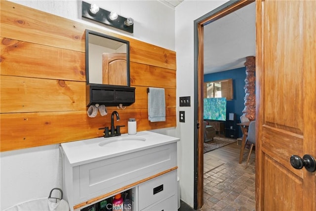 bathroom featuring vanity and wood walls