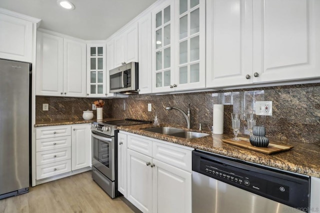 kitchen with stainless steel appliances, sink, and white cabinets