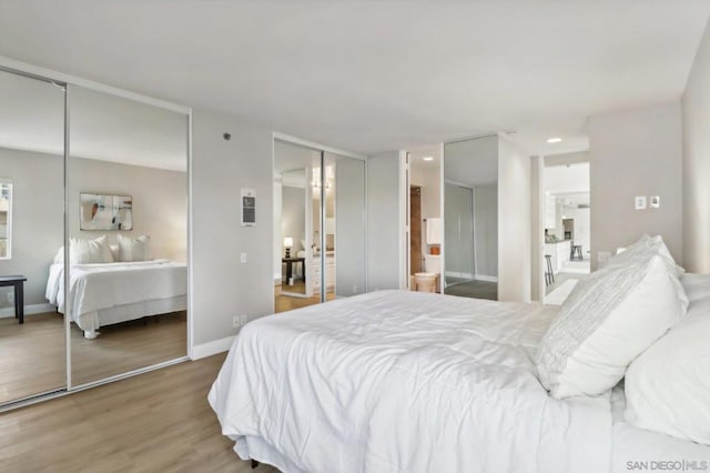 bedroom with connected bathroom and hardwood / wood-style flooring