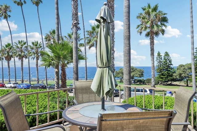 view of patio featuring a water view and a balcony