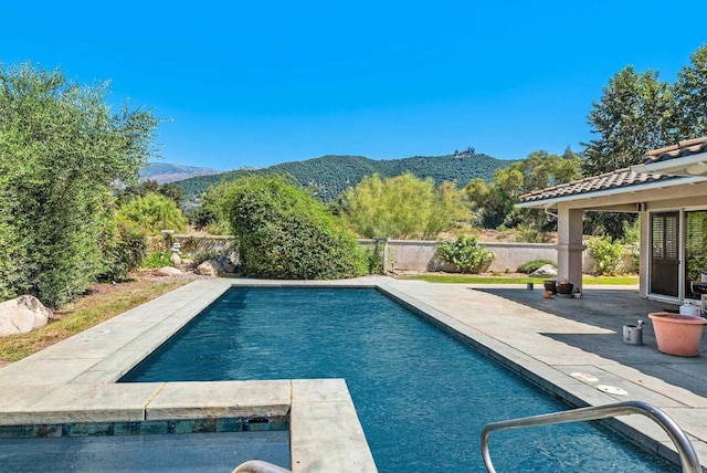 view of swimming pool with a mountain view and a patio area