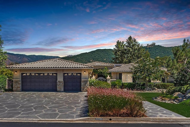 view of front of home with a garage and a mountain view