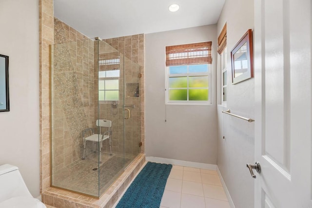 bathroom featuring walk in shower, plenty of natural light, toilet, and tile patterned flooring