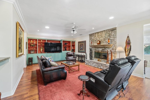 living room featuring crown molding, hardwood / wood-style flooring, and a fireplace