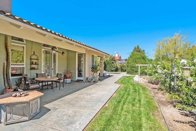 view of yard with an outdoor fire pit, ceiling fan, and a patio area