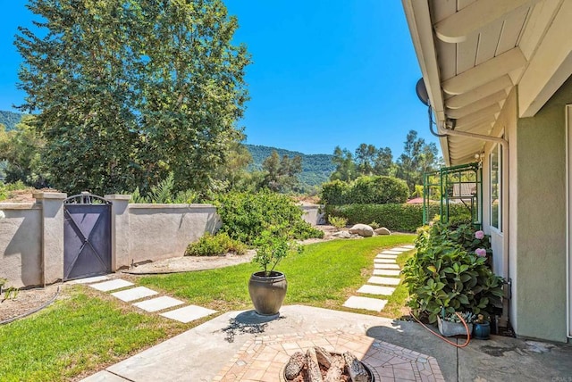 view of yard with a fire pit, a mountain view, and a patio area