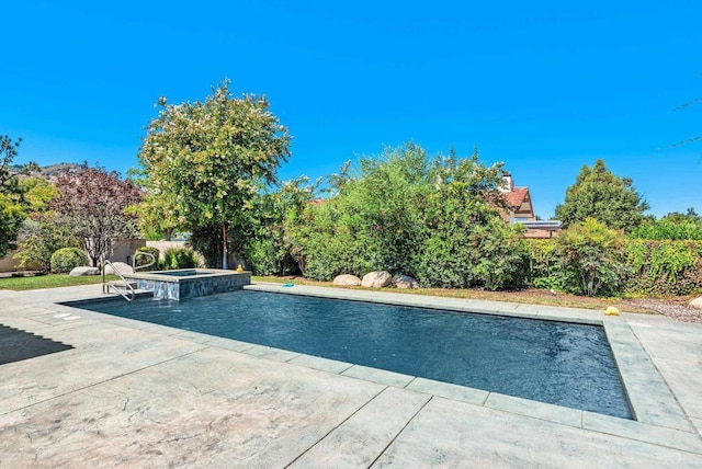 view of swimming pool featuring a patio and an in ground hot tub