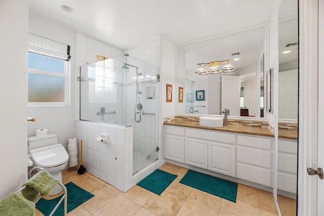 bathroom featuring tile patterned flooring, vanity, a shower with shower door, and toilet