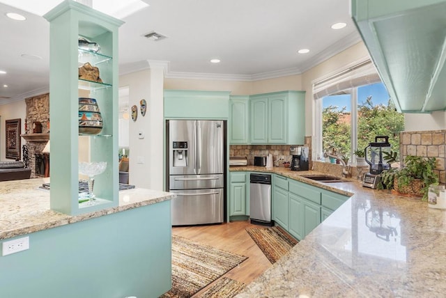 kitchen featuring crown molding, sink, stainless steel fridge, and light hardwood / wood-style floors