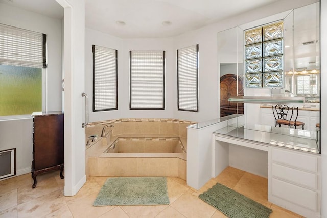 bathroom with a relaxing tiled tub, a wealth of natural light, and tile patterned floors