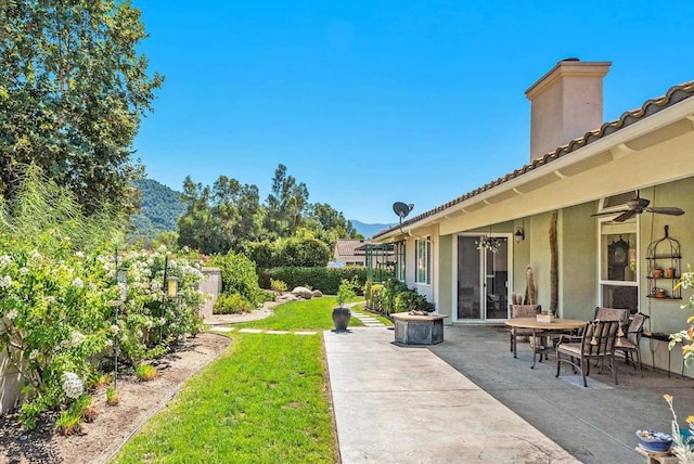 view of yard with a mountain view, a patio area, and ceiling fan