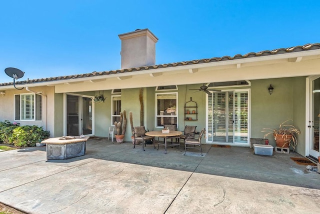 back of house with ceiling fan and a patio area