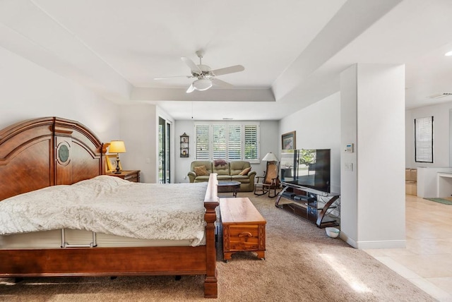 carpeted bedroom featuring a raised ceiling and ceiling fan